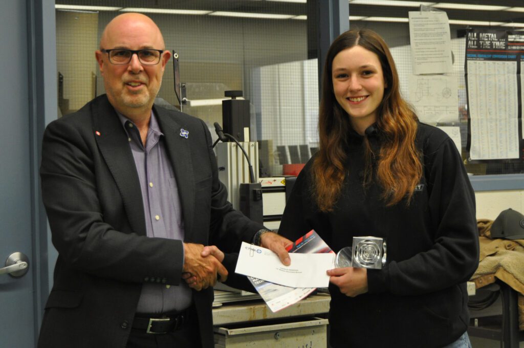 Female student being presented with CTMA award and cheque.